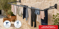 Hills Compact Folding Frame Clothesline – Monument mounted on a Mediterranean stone wall with laundry drying on the lines.