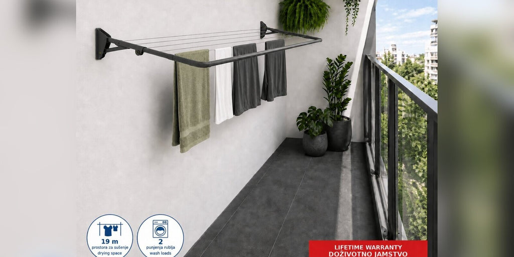 Hills Compact Folding Frame Clothesline – Monument mounted on a balcony wall with laundry drying on the lines.
