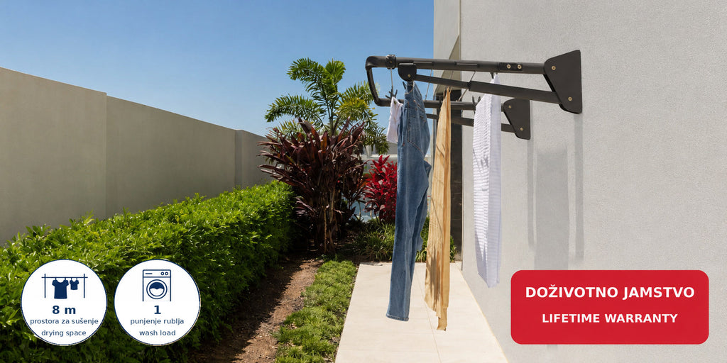 Hills Mini Folding Frame Clothesline mounted on an outdoor wall beside a garden walkway.